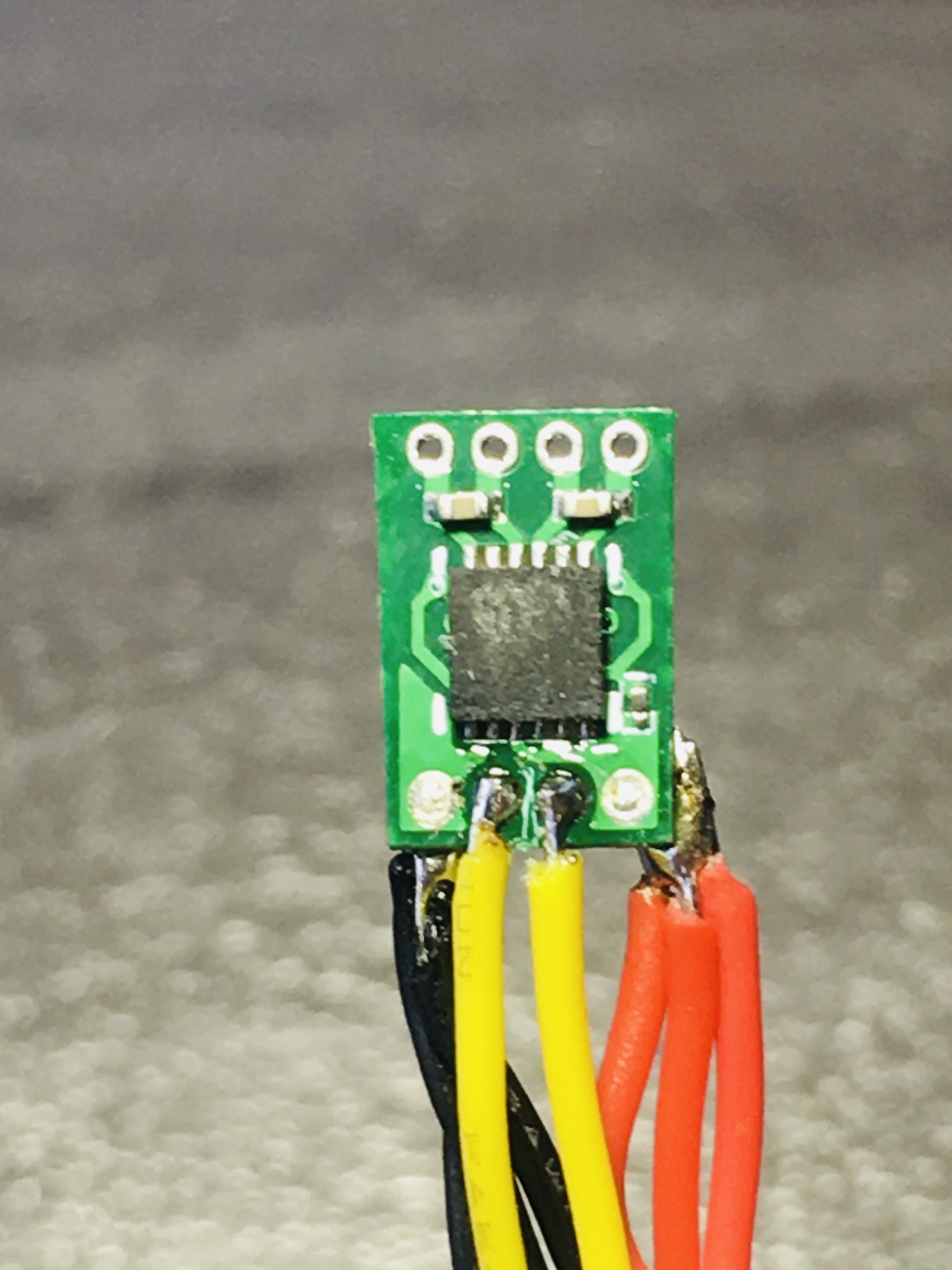 The yellow PPM signal wires are soldered on the back side of the ESC after the center pads are tinned.
