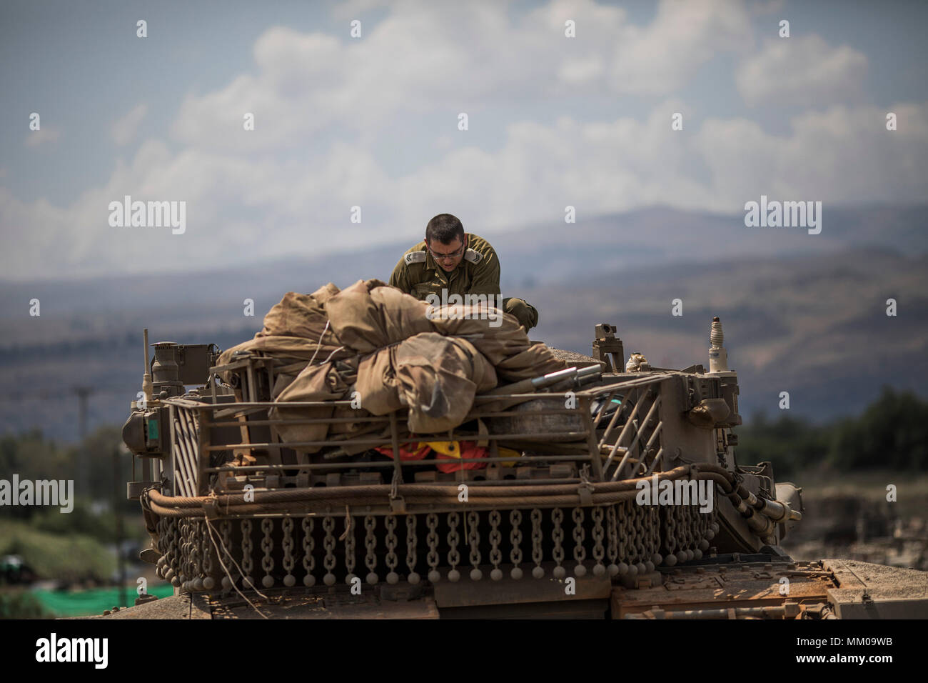 golan-heights-israel-09th-may-2018-an-israeli-soldier-on-top-of-a-merkava-mark-iv-tank-that-deployed-along-the-border-with-syria-in-golan-heights-israel-09-may-2018-israels-army-is-mobilizing-reserv.jpg