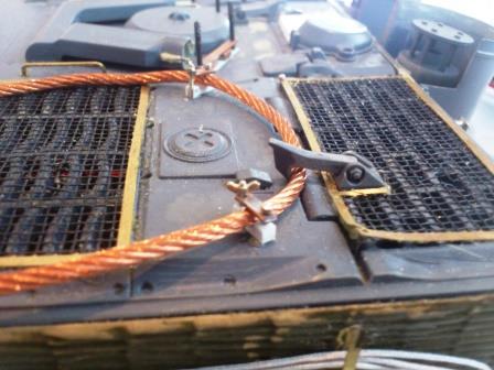 In photos of the real thing you often see the rear deck hatch hooks over the tow ropes like this.jpg