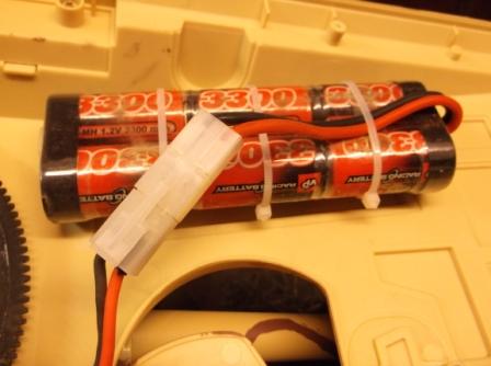 Battery secured to underside of engine deck using a piece of plastic with brass tubes imbedded to take small cable ties.