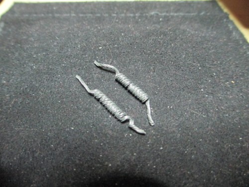 Springs made from picture wire hand coiled around a brad