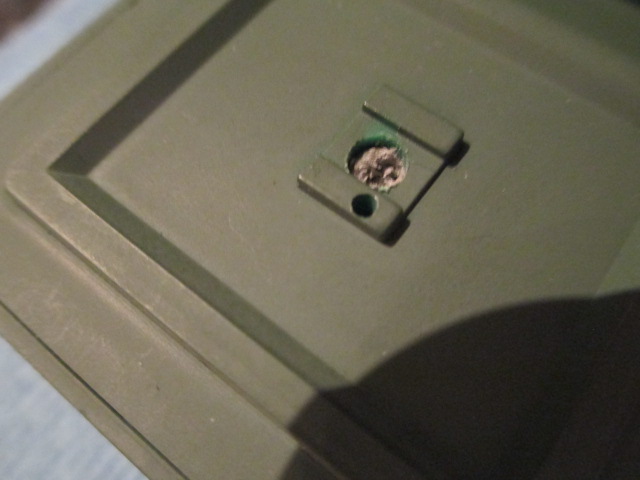 Rear hatch interior with drilled out Pistol Port and mounting hole for the pin hinge.  The crumbly material is a rubber washer inserted before it was drilled out.