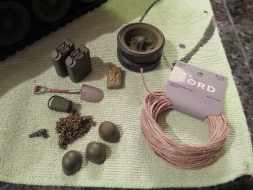Collected stowage pieces include original jerry cans and plastic and metal helmets.  Alpha's bucket.  Chain, .45, an original road wheel repainted along with a salvage shovel