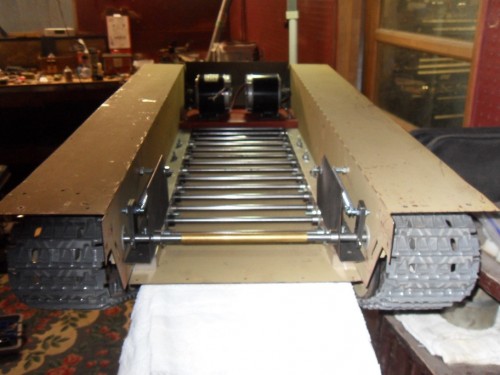 The heart of my design a solid foundation to build from. 1.125 aluminum rails, every component uses these twin rails as a foundation.Hull,drive,battery tray,all bolt to this rails. Because the torsion rods mount through the rails and are directly supported by the rails' weight is dispersed evenly across the hull. Yet since the actual hull sides do not contact the rods no structural stress is transmitted through the hull. Track ground pressure is minimal and allows  the tank to be very agile and very maneuverable.