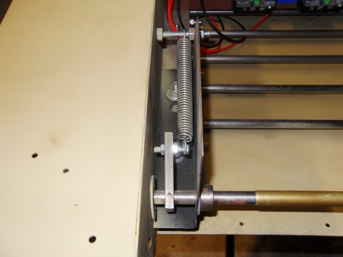Tension assembly,simple yet effective solution to variable track pressure caused by terrain changes.The shaft mounts in to a small flange bearing same as the wheel bearings. once inserted the shaft has a set collar which slides against a thrush washer press fitting the bearing in place.The Rail mounted bracket uses a set collar to further lock the assembly in place.The shaft can freely pivot,but is retained by the collars from side to side movement,This also provides rear hull strength against flexing.Once the back plate is attacked the strength exceeds the tension wheels torque having negative effect on the pitch or angle of the wheel. Bottom line ,no thrown tracks.The shafts meet in the hull center,and are held in position by a brass sleeve. This allows each side independant rotation.