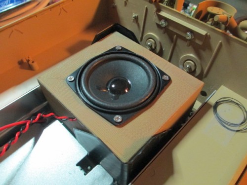 Speaker box mounted with flexible corners and Velcro squares.
