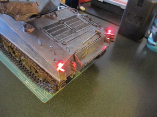 The tail lights come on when the engine sound is started up and remain on until the tank's engine sound is shut down.
