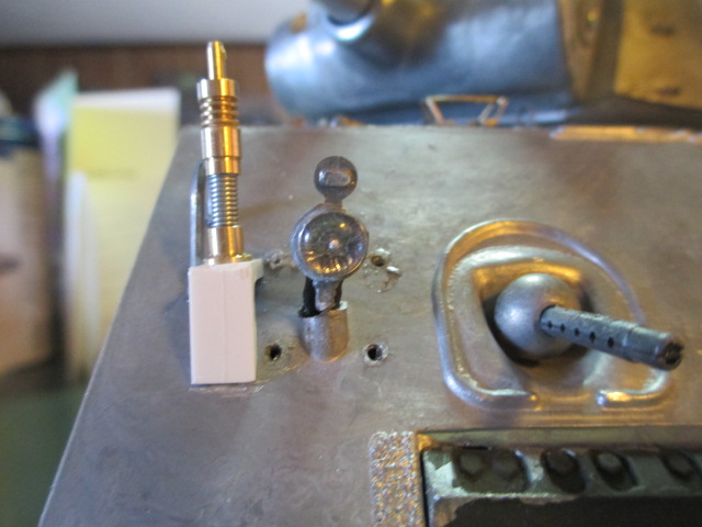 Hole drilled and wire glued.  Headlight braces removed.  Loc Tite Epoxy added to simulate a weld.  The base is screwed into the plastic beam.  A nut and washer hold it in place.