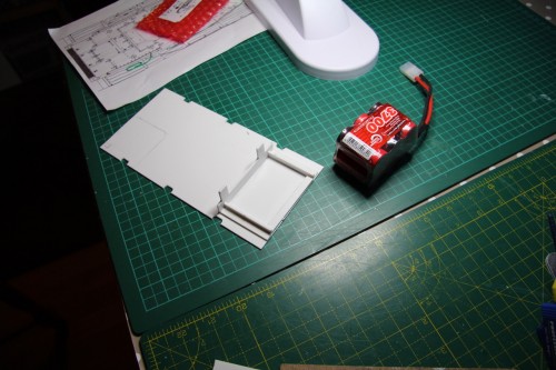 Battery tray shaped to fit tank floor
