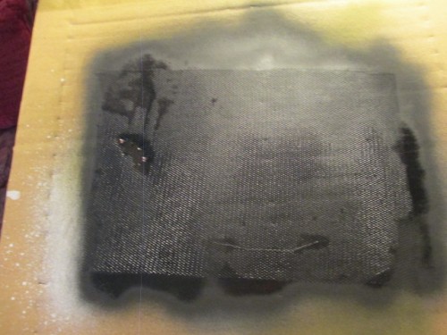 I resolved this issue by spraying a piece of the material with flat black.  Once this dried, it was much easier to measure and cut.