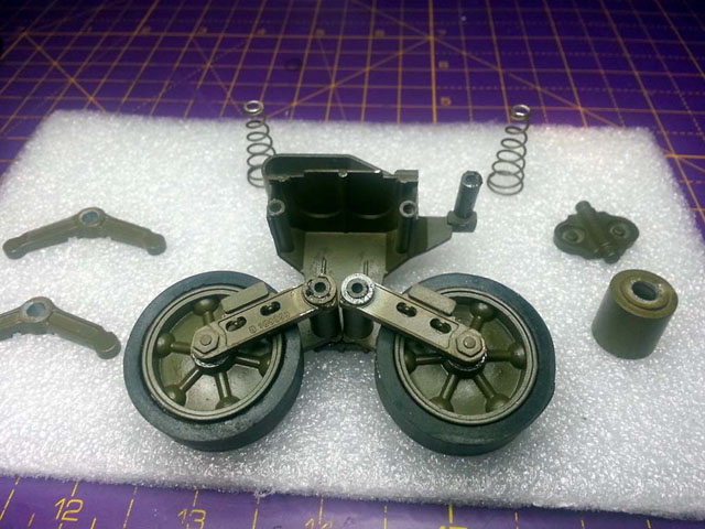 Here is an example of the wheels now assembled on the pivot arms. The springs, sliding arms, etc, are yet to be added. As can be seen, all the pivoting points, including the return roller, have been lightly lubricated (moly - the excess is cleaned up before putting back in the hull of course)