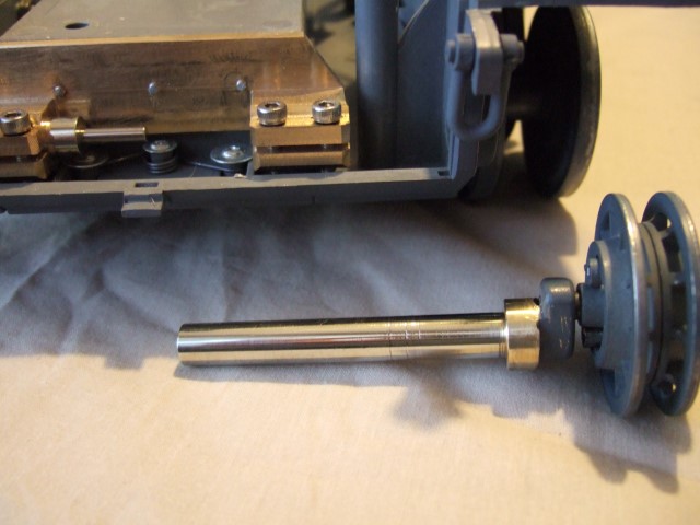 The main axle has a 5 mm offset arm with a 5 mm socked head bolt with a M 4 mm threaded end that screws into the offset arm. The idler wheel needs to have a 5 mm hole drilled through its back part.