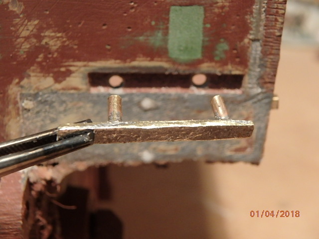 Drilled out 2 holes in stock mounting slot for brass rod to slide through hull.
