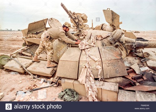a-qatar-soldier-examines-a-destroyed-iraqi-t-55-battle-tank-during-FMAEHK.jpg